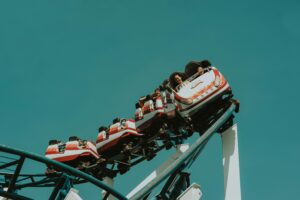 A group of people enjoying a thrilling roller coaster ride at an amusement park.